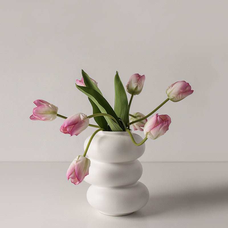 Triple Stack Orb Vase, matte white ceramic with rounded tiered form holding soft pink tulips