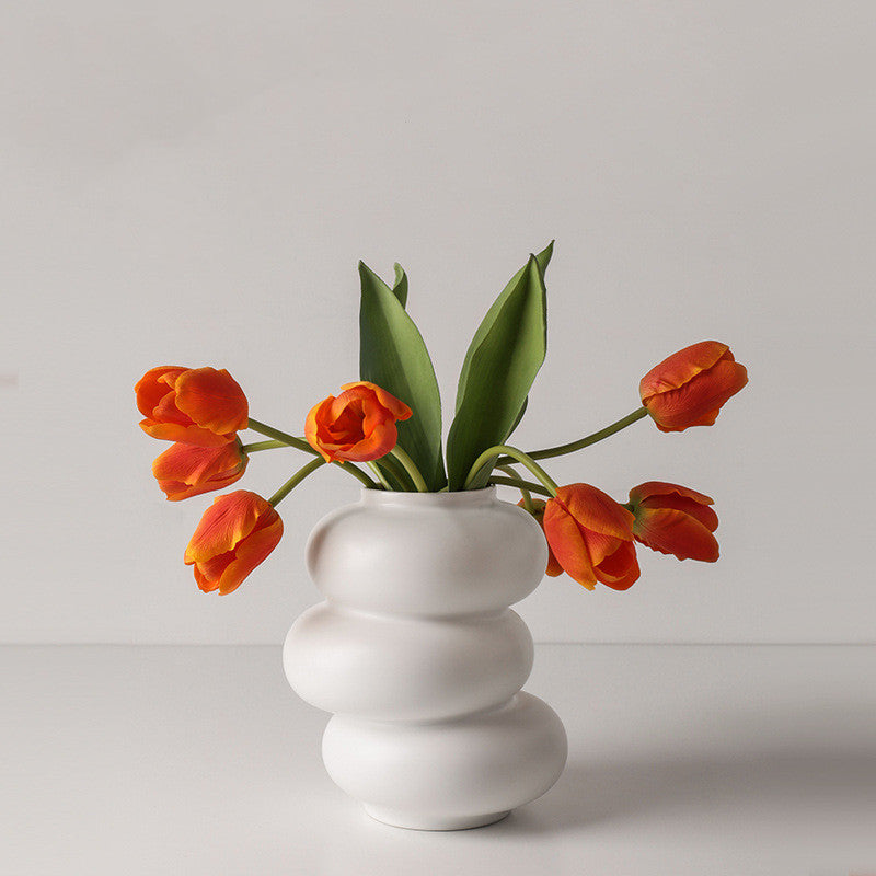 Triple Stack Orb Vase, matte white ceramic with rounded tiered form holding vibrant orange tulips