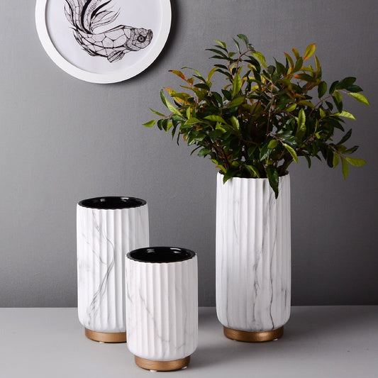 Fluted Marble Vase Set, white marble with vertical ribbed texture and wood base accents styled with greenery