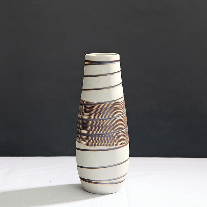 Ceramic vase with striped design on a dark background