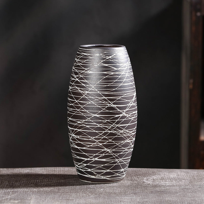Decorative vase with white line pattern on a dark background