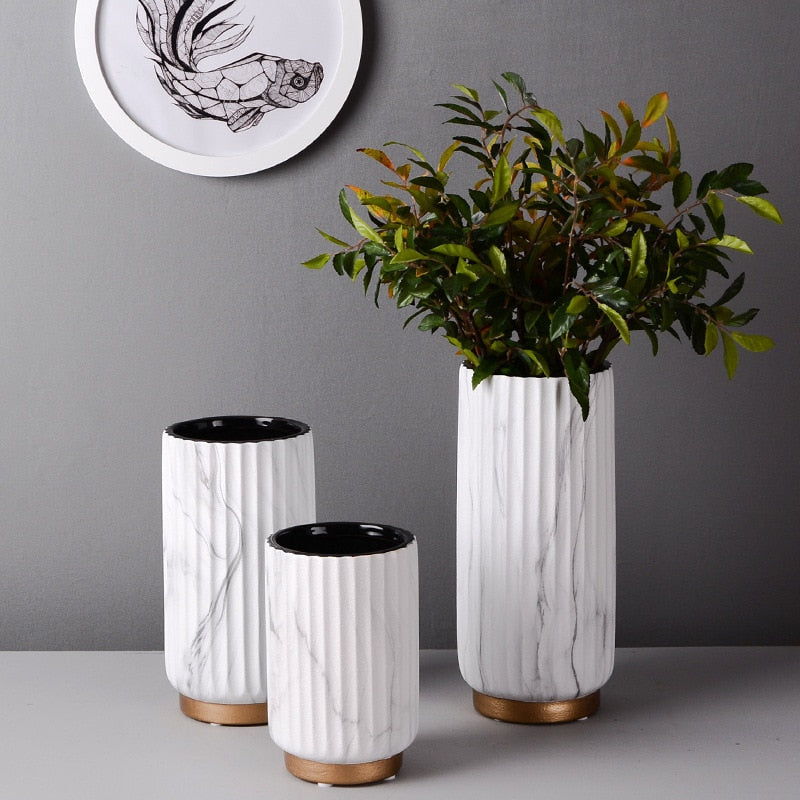 Fluted Marble Vase Set, white marble with vertical ribbed texture and wood base accents styled with greenery