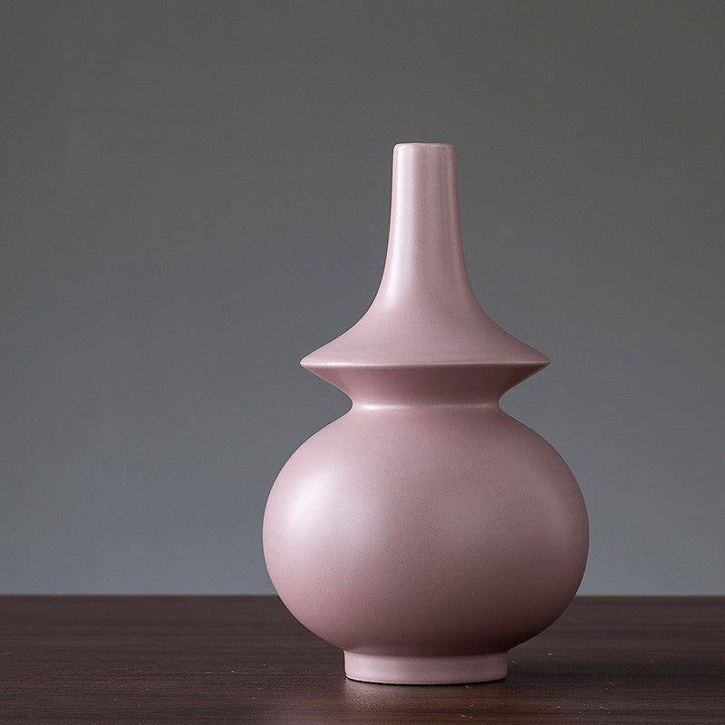 Pink ceramic vase on a wooden surface with a gray background