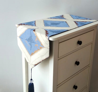 Geometric Patchwork Table Runner, cream fabric with soft blue panels and angular pattern with tassel detail
