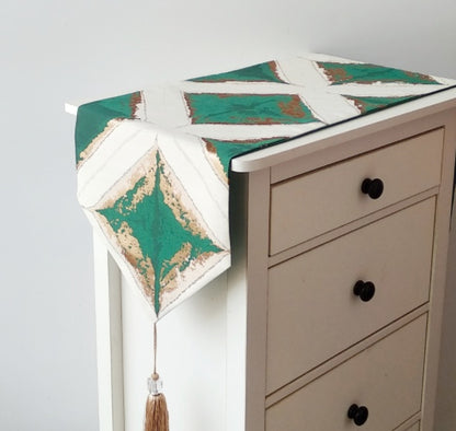 Geometric Patchwork Table Runner, cream fabric with deep green panels and textured angular pattern with tassel detail