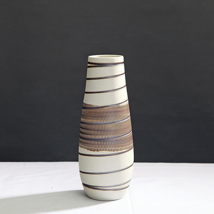 Ceramic vase with striped design on a dark background
