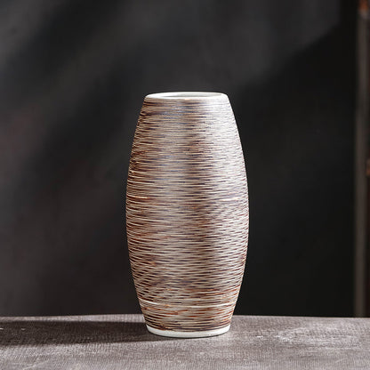 Oval hand-textured ceramic vase with fine horizontal line pattern on dark grey background