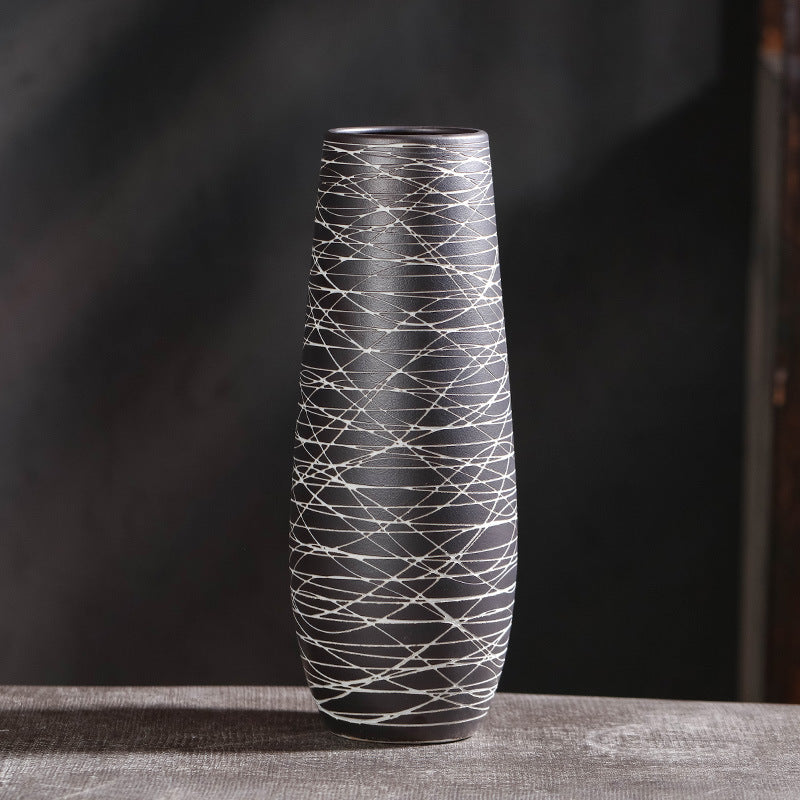 Tall black and white patterned vase on a dark background