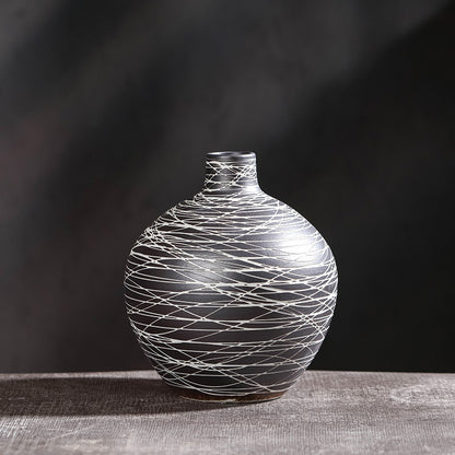Decorative vase with string-like pattern on a dark background