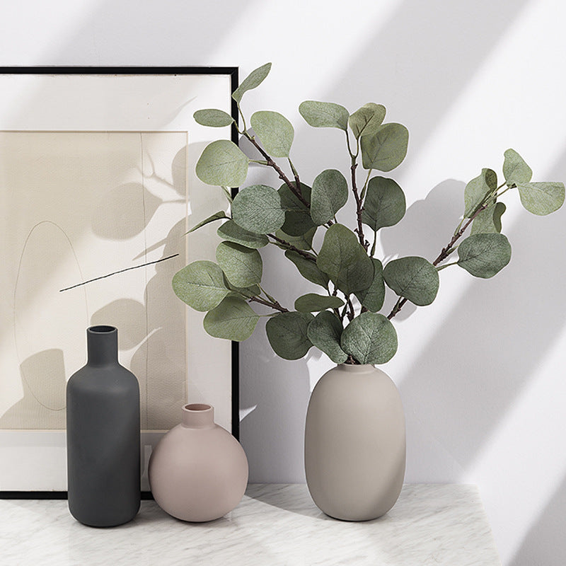 Minimal Ceramic Vase Trio, matte neutral-toned ceramics in bottle, round, and oval silhouettes styled with eucalyptus stems