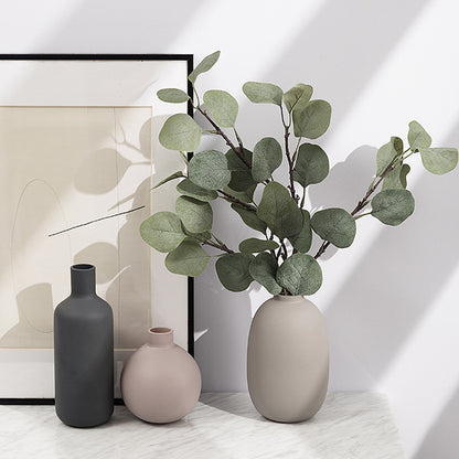 Minimal Ceramic Vase Trio, matte neutral-toned ceramics in bottle, round, and oval silhouettes styled with eucalyptus stems