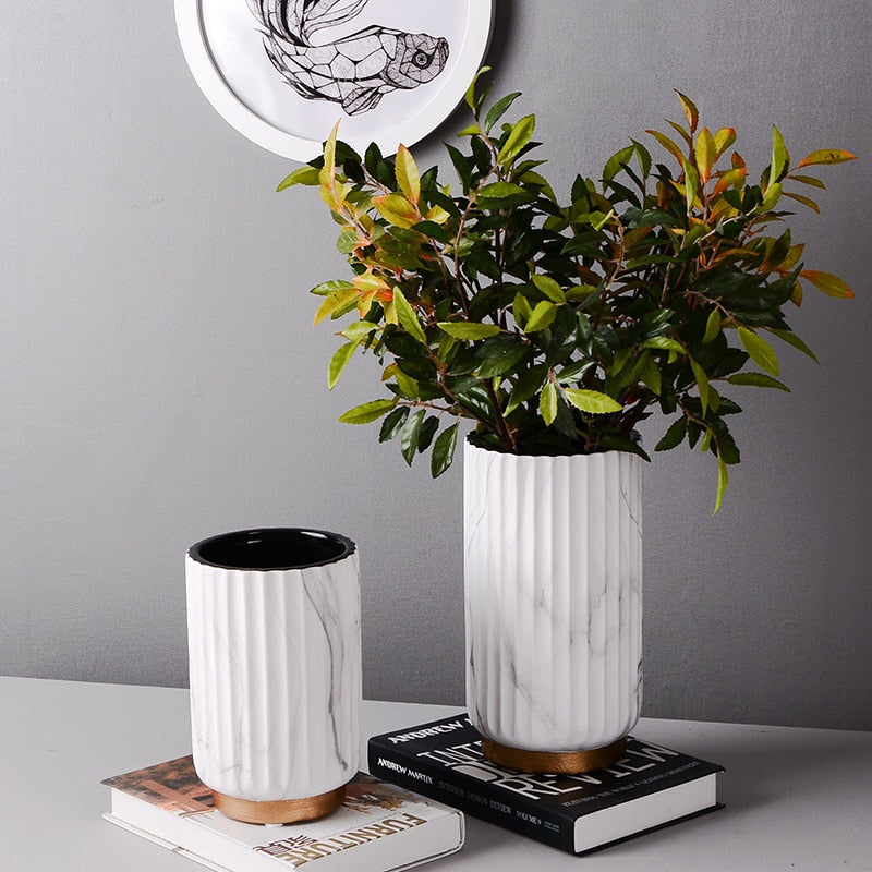 Fluted Marble Vase Set, white marble with vertical ribbed texture and wood base accents styled with leafy greenery
