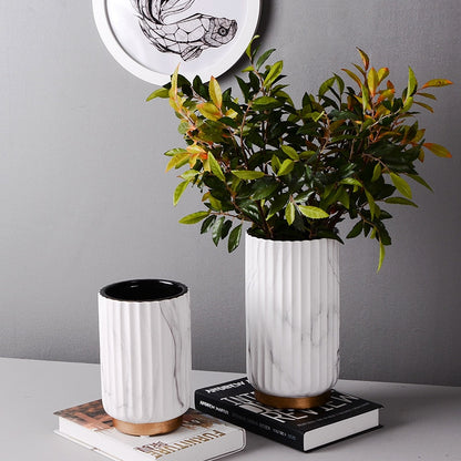 Fluted Marble Vase Set, white marble with vertical ribbed texture and wood base accents styled with leafy greenery