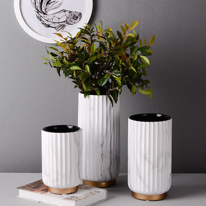 Fluted Marble Vase Set, white marble with vertical ribbed texture and wood base accents styled with lush greenery