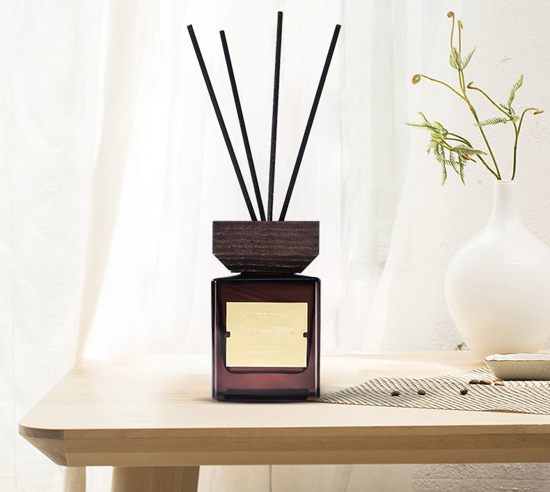 Luxury Reed Diffuser, amber glass fragrance bottle with wooden cap and black reed sticks for long-lasting home aromatherapy
