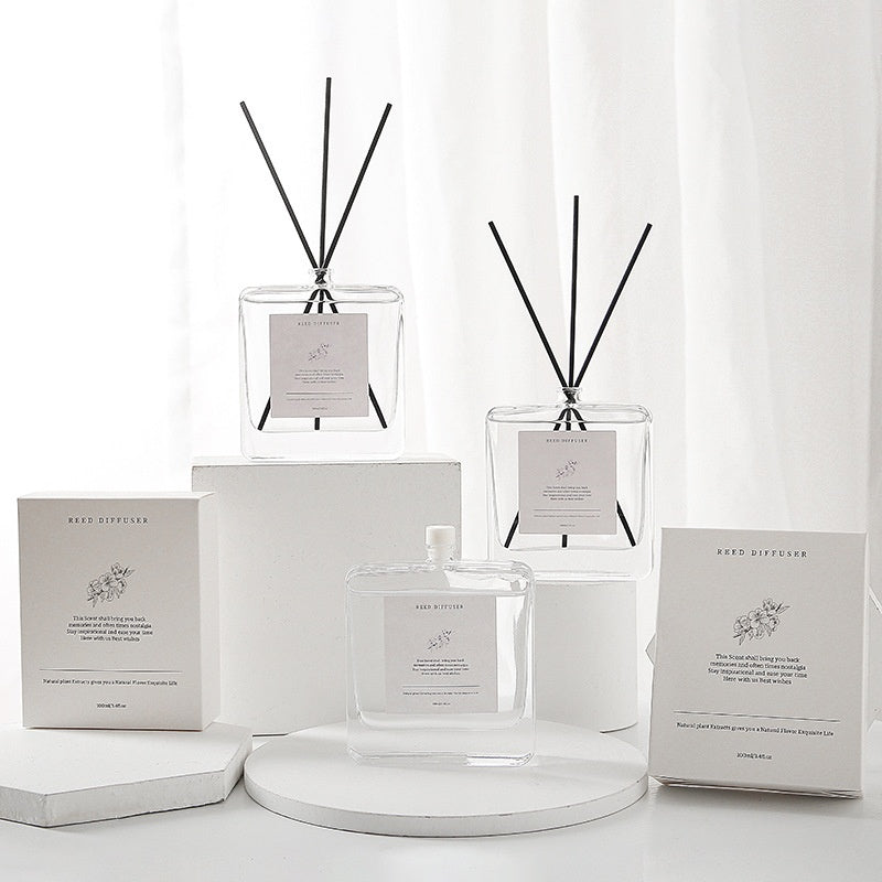 Minimalist Glass Reed Diffuser Set, clear square bottles with black reed sticks and elegant white packaging for modern home fragrance decor