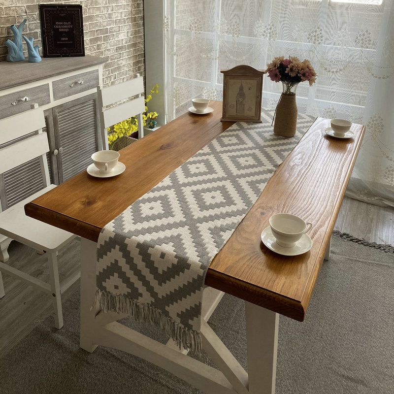 Geometric Diamond Table Runner, gray woven fabric with cream diamond pattern and tasseled edges