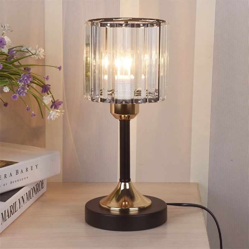 Crystal Column Table Lamp, clear ribbed glass shade with black and gold metal base and warm glowing light