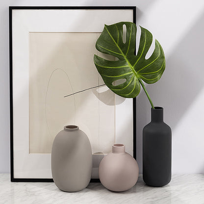 Minimal Ceramic Vase Trio, matte neutral-toned ceramics in oval, round, and bottle silhouettes styled with monstera leaf