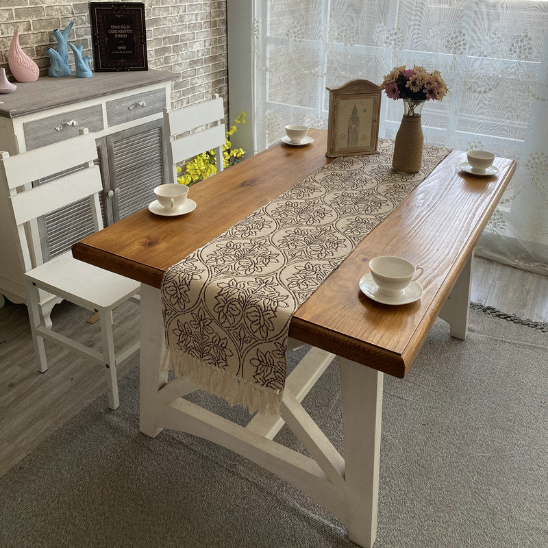 Floral Pattern Table Runner, beige woven fabric with intricate black botanical design and tasseled edges