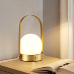 Modern Arc Table Lamp, frosted dome glass shade with gold metal handle frame and soft ambient glow