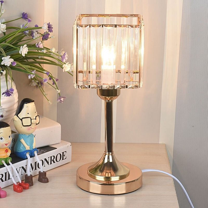 Crystal Square Table Lamp, clear faceted glass shade with gold metal base and warm ambient glow
