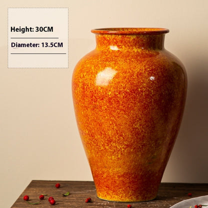 Orange ceramic vase on a wooden surface with dimensions displayed.